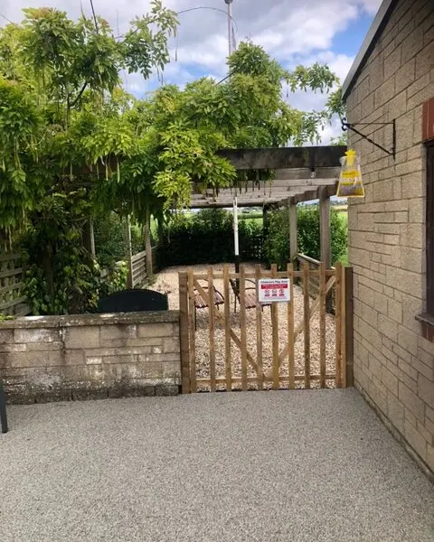 The gate to the outdoor area beneath a wisteria-covered pergola